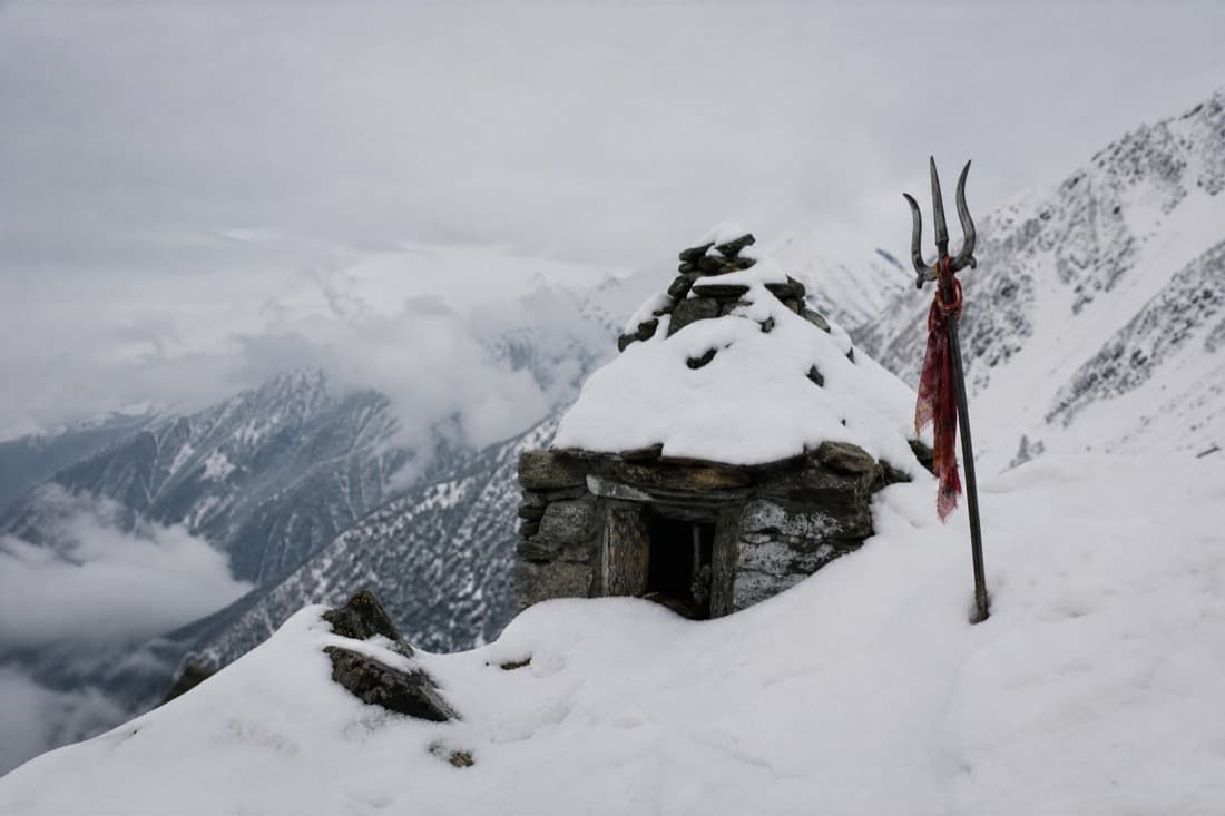 A small stone shrine half buried in snow
